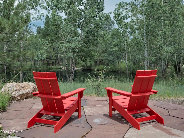 view of patio / terrace featuring a water view and a wooded view