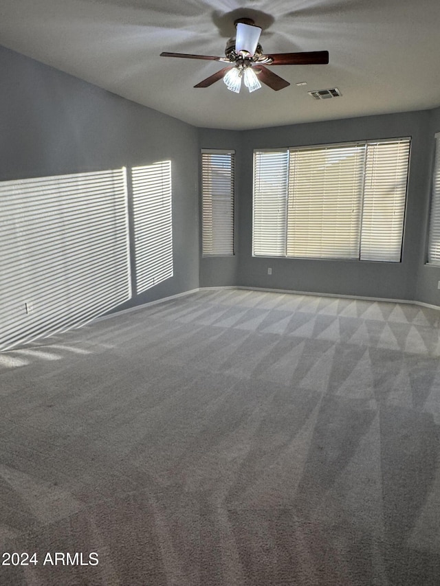 carpeted spare room featuring ceiling fan