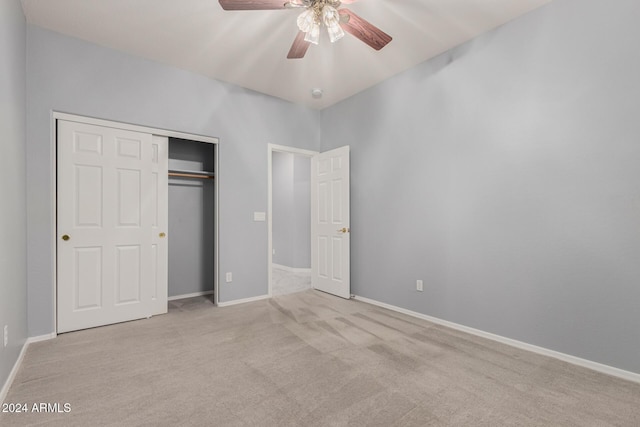 unfurnished bedroom featuring ceiling fan, a closet, and light carpet