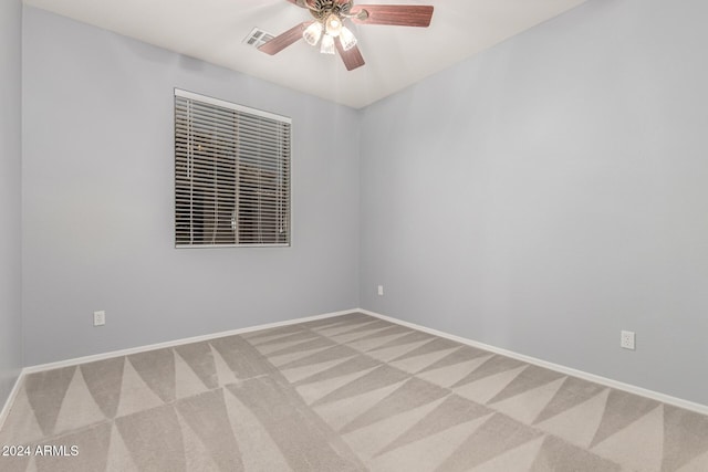 empty room with ceiling fan and light colored carpet