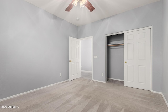 unfurnished bedroom with ceiling fan, a closet, and light colored carpet