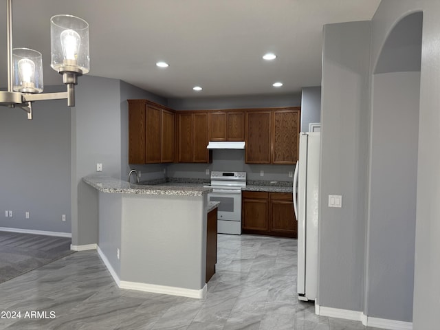 kitchen featuring pendant lighting, white appliances, sink, light stone counters, and kitchen peninsula