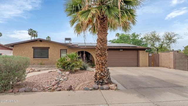 4417 W Sandra Cir, Glendale, AZ 85308 - ranch-style house featuring a garage, driveway, stucco siding, and roof mounted solar panels