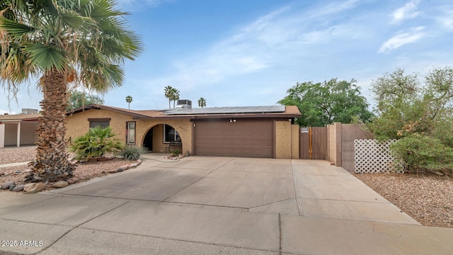 4417 W Sandra Cir, Glendale, AZ 85308 - ranch-style house featuring concrete driveway, stucco siding, an attached garage, fence, and roof mounted solar panels