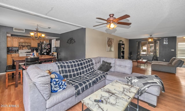 4417 W Sandra Cir, Glendale, AZ 85308 - living area with visible vents, light wood-type flooring, a textured ceiling, and ceiling fan with notable chandelier