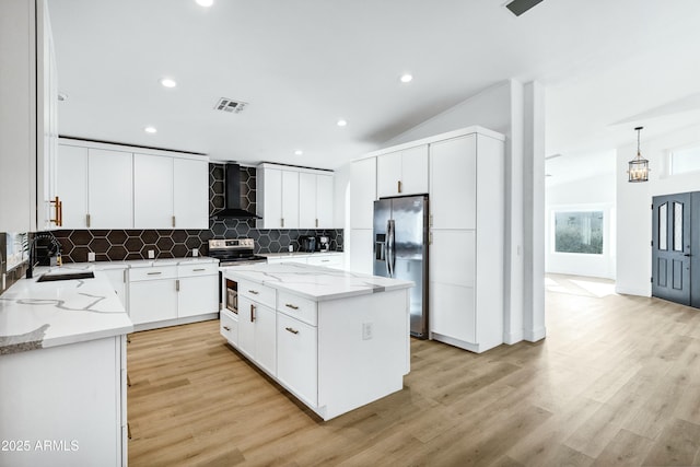 kitchen with white cabinetry, sink, a center island, wall chimney exhaust hood, and appliances with stainless steel finishes