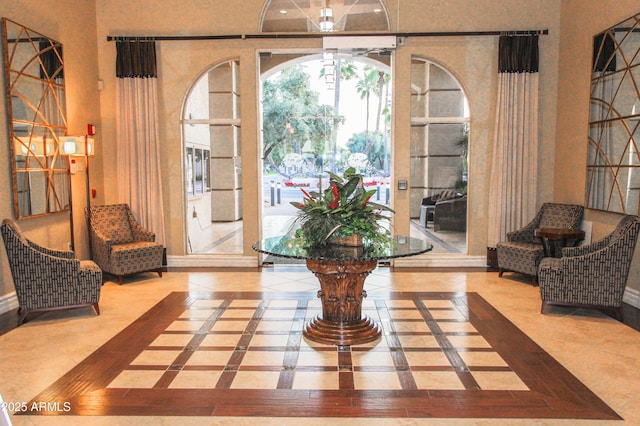 sitting room featuring inlaid floor details and baseboards