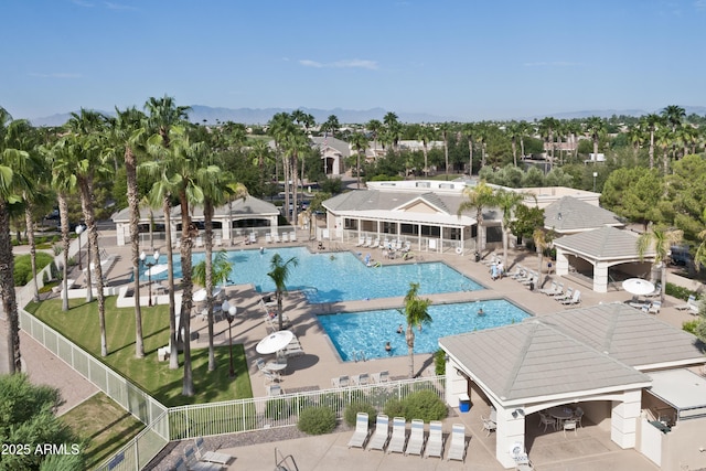 community pool featuring fence and a patio