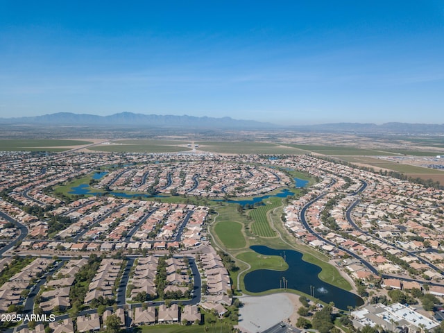 aerial overview of property's location featuring nearby suburban area, a water and mountain view, and a golf course