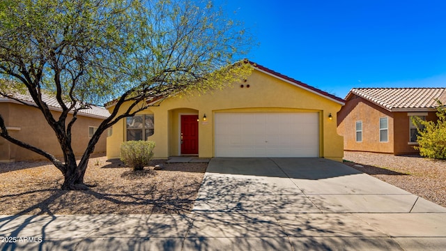 view of front of property with concrete driveway, a tiled roof, an attached garage, and stucco siding