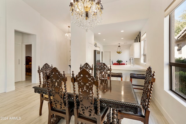 dining area featuring light hardwood / wood-style floors and a notable chandelier