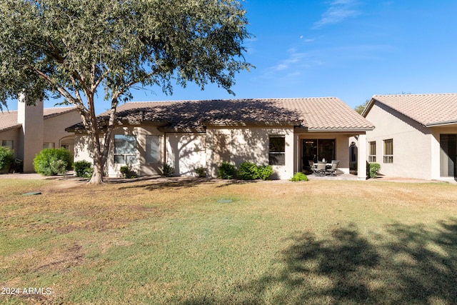 back of property featuring a patio and a yard