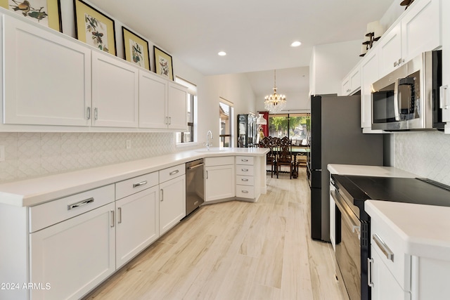 kitchen featuring decorative backsplash, white cabinets, stainless steel appliances, and hanging light fixtures