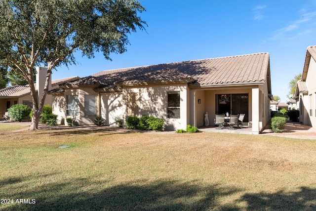 rear view of property with a patio area and a lawn