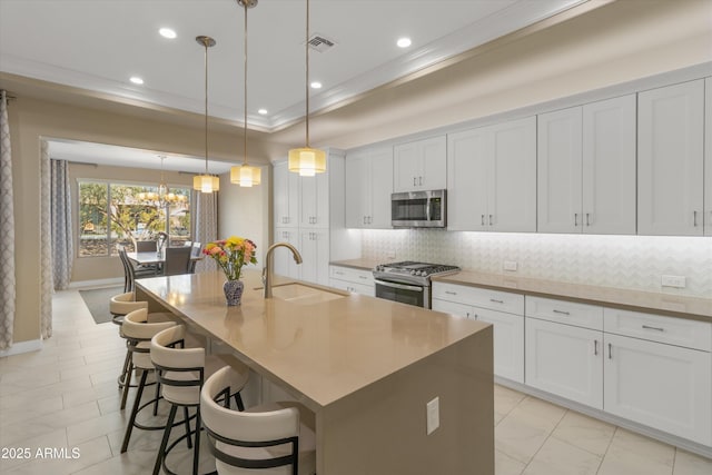 kitchen with white cabinetry, a large island with sink, and appliances with stainless steel finishes