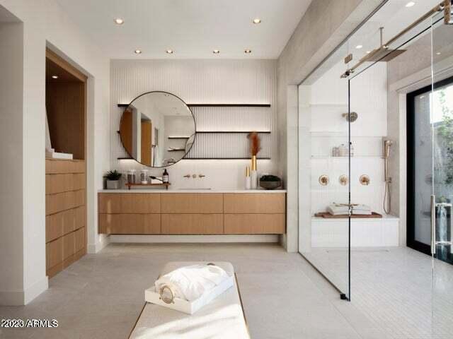 bathroom with a shower, vanity, and concrete floors