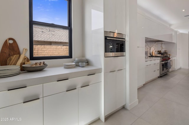 kitchen with white cabinetry, stainless steel appliances, and light tile patterned floors