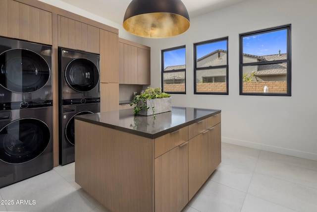 laundry area featuring cabinets, light tile patterned floors, washing machine and dryer, and stacked washer and dryer