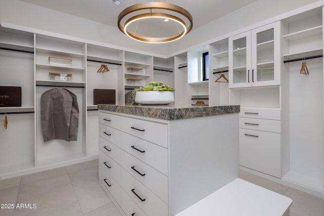 walk in closet with light tile patterned floors