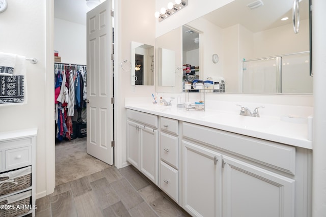 bathroom featuring vanity and a shower with door