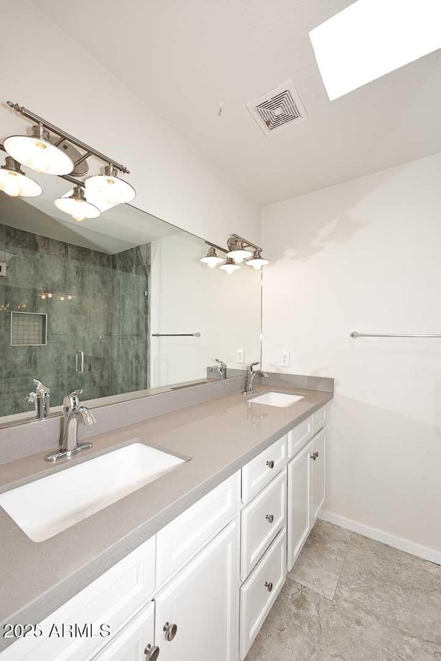 bathroom featuring vanity, a skylight, and a shower with shower door