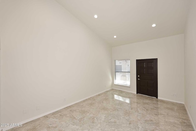 unfurnished room featuring lofted ceiling