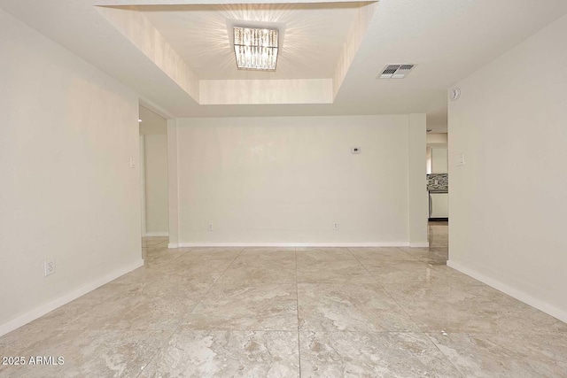 spare room with a tray ceiling