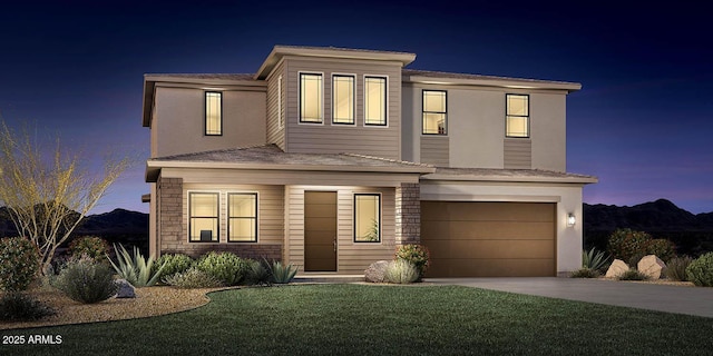 view of front of house with concrete driveway, a garage, and a front yard