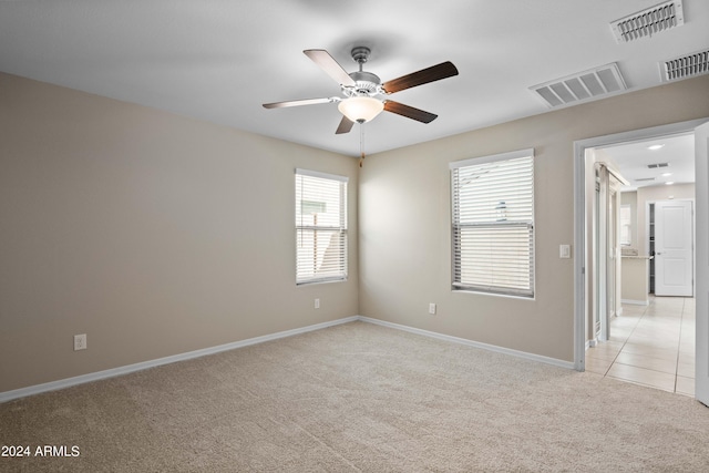 carpeted spare room featuring ceiling fan