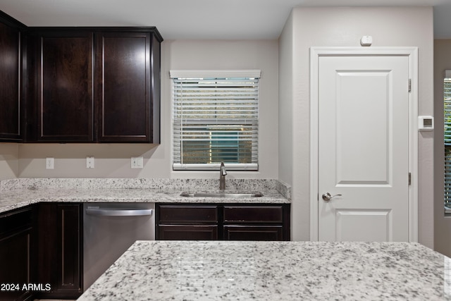 kitchen featuring dark brown cabinetry, sink, light stone countertops, and dishwasher