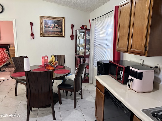 dining space with light tile patterned flooring and a textured ceiling