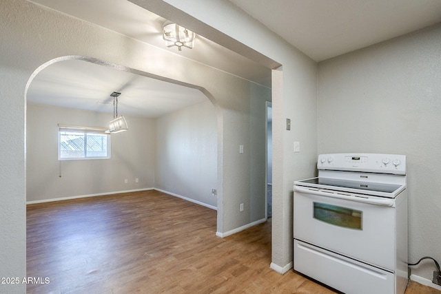 kitchen with electric stove, hanging light fixtures, and light hardwood / wood-style floors