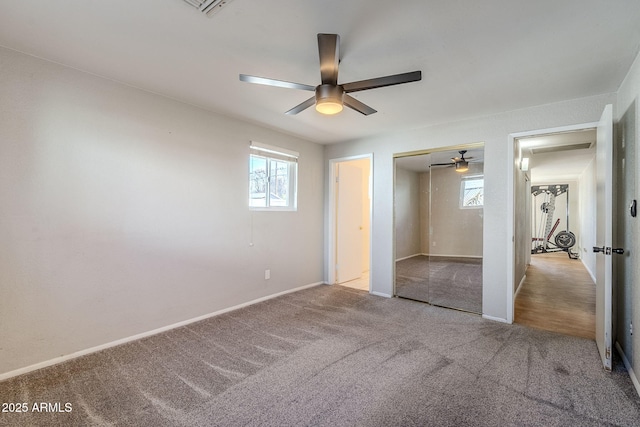 unfurnished bedroom featuring ceiling fan, a closet, and light carpet