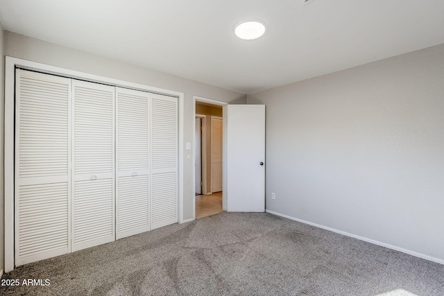 unfurnished bedroom featuring light colored carpet and a closet