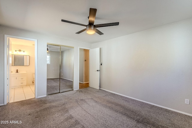 unfurnished bedroom with carpet floors, sink, a closet, ceiling fan, and ensuite bathroom