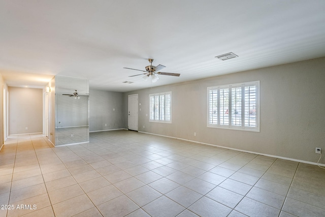 tiled empty room featuring ceiling fan