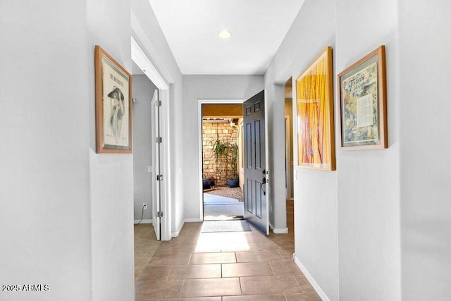 hallway featuring tile patterned flooring and baseboards