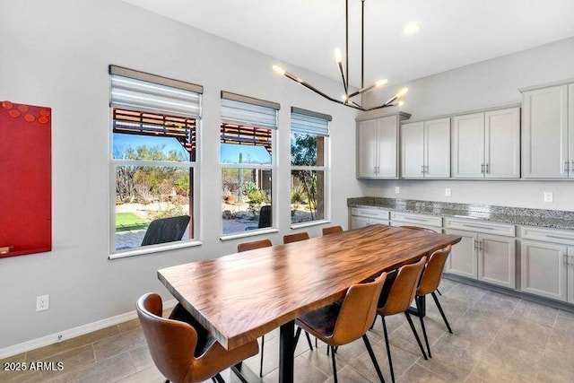 dining area featuring baseboards and a chandelier