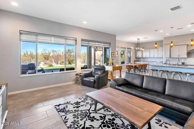 living area featuring light tile patterned floors, recessed lighting, visible vents, baseboards, and an inviting chandelier