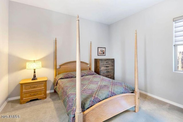 bedroom with baseboards and light colored carpet