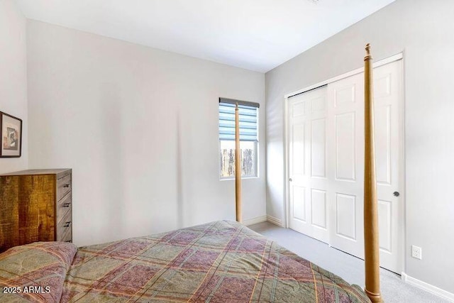 bedroom featuring a closet, light colored carpet, and baseboards