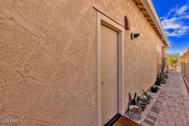 view of home's exterior with fence and stucco siding