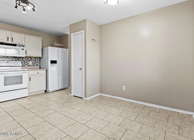 kitchen with backsplash, white appliances, and white cabinets