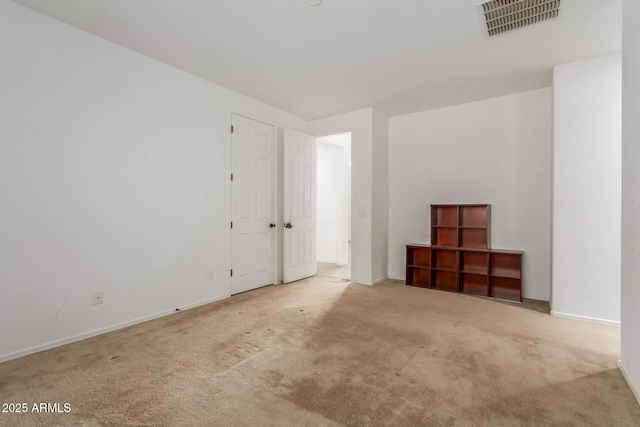 spare room featuring light colored carpet