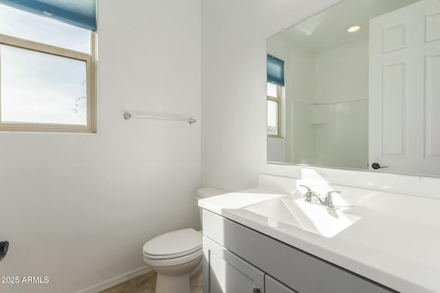 bathroom with vanity, a healthy amount of sunlight, walk in shower, and toilet