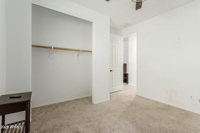 unfurnished bedroom featuring light carpet, ceiling fan, and a closet