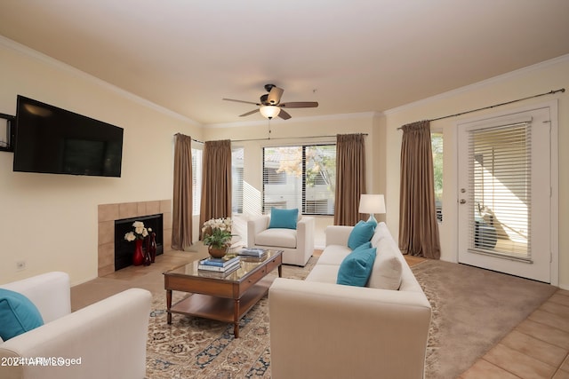 living room featuring ornamental molding, light tile patterned floors, a tile fireplace, and ceiling fan