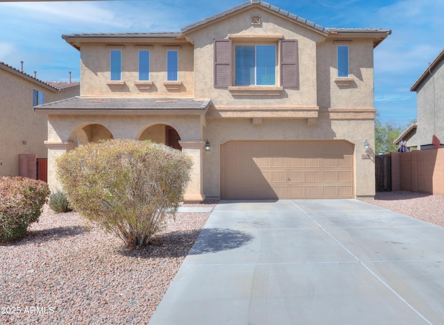 view of front of house with a tile roof, a garage, driveway, and stucco siding