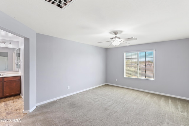 unfurnished room featuring ceiling fan, visible vents, baseboards, and light carpet