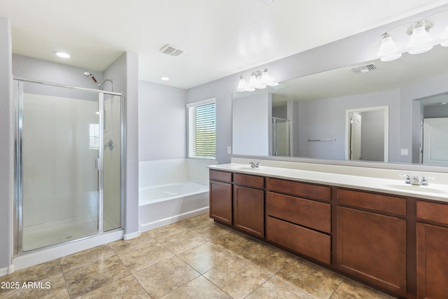 bathroom featuring a stall shower, a bath, visible vents, and a sink